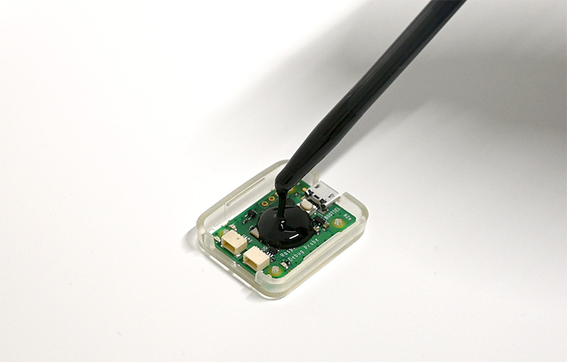 Potting of the black ISO-PUR® BD50-S casting resin on an electronic component