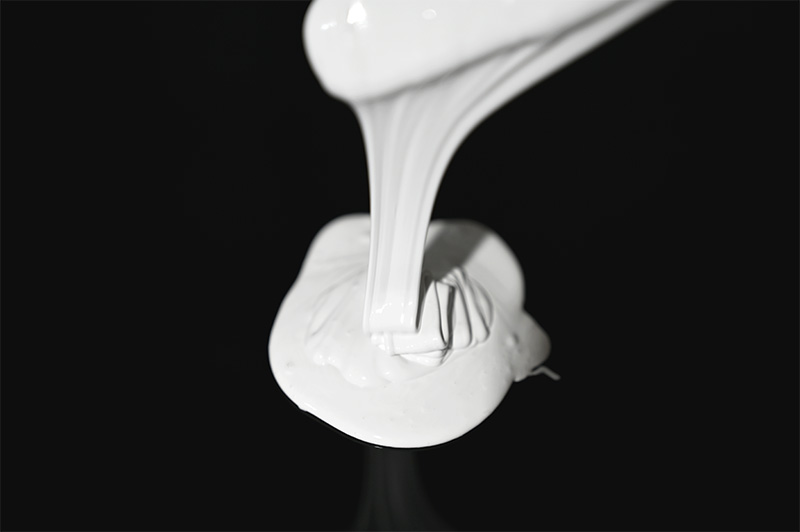 White viscous ISO-SIL 150.000 potting material on a black background.