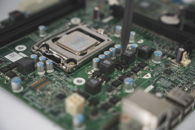 Makroaufnahme einer Elektronik auf die eine schwarze Vergussmasse appliziert wird