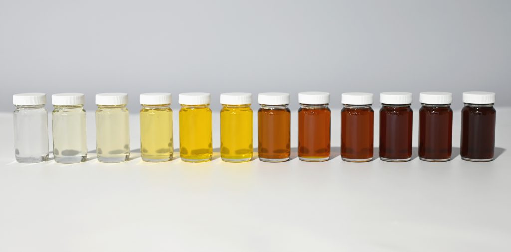 Transparente Gläser, gefüllt mit verschiedenen Isocyanaten; von transparent über gelb bis braun.